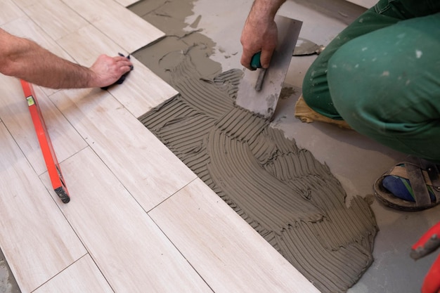 Laying terracotta in the bathroom Builder during work Adhesive for ceramic tiles