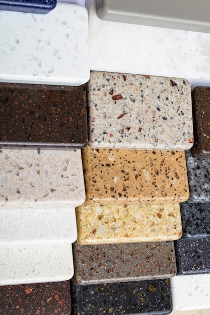 Layout: colorful specimens of granite, marble and quartz natural stone slabs.Close-up of stone kitchen countertops samples