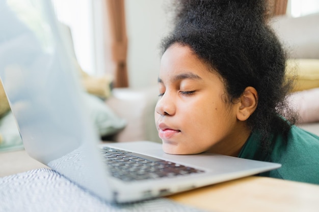 Lazy African American girl with the computer before studying online at home