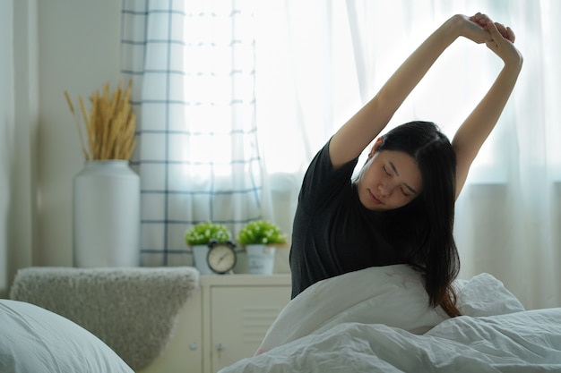 Lazy woman waking up in the morning