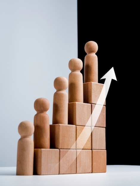 Leadership with business success concept. Modern rising up arrows and wooden figures standing on growth graph chart step arranged by wood cube blocks on white and black background, vertical style.