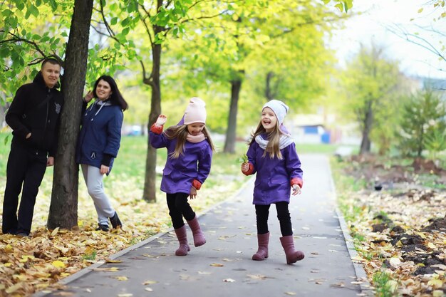 Leaf fall in the park. Children for a walk in the autumn park. Family. Fall. Happiness.