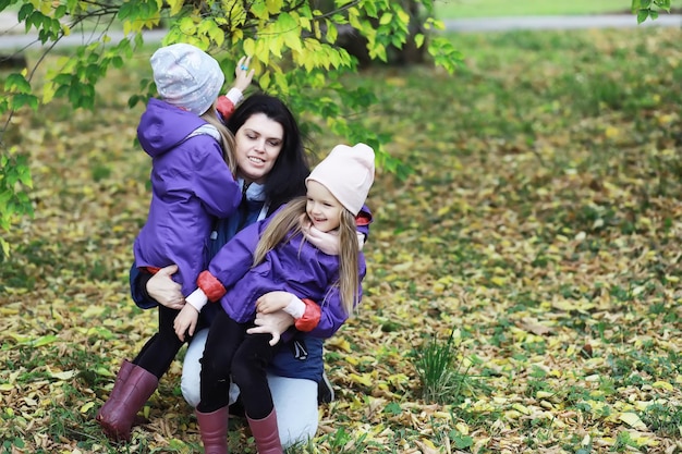 Leaf fall in the park. Children for a walk in the autumn park. Family. Fall. Happiness.