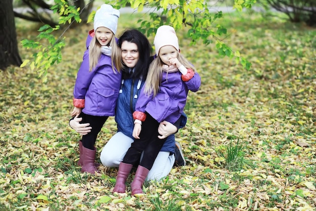 Leaf fall in the park. Children for a walk in the autumn park. Family. Fall. Happiness.