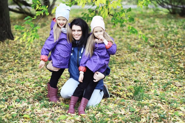 Leaf fall in the park. Children for a walk in the autumn park. Family. Fall. Happiness.