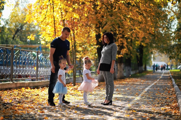 Leaf fall in the park. Children for a walk in the autumn park. Family. Fall. Happiness.