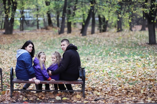 Leaf fall in the park Children for a walk in the autumn park Family Fall Happiness