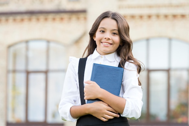 Learning language Hooked on learning School life Child development Excited about studying School education concept Cute smiling child hold book Little girl school student Knowledge day