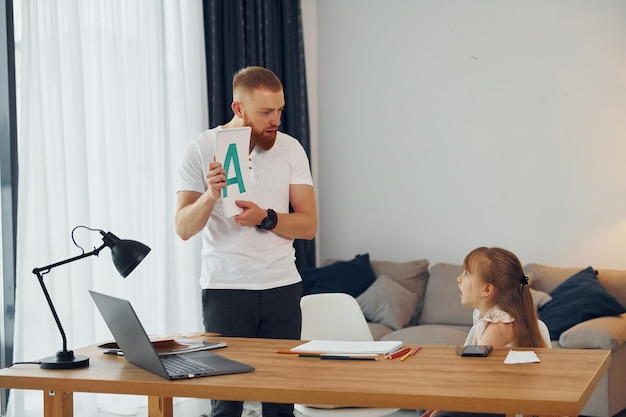 Learning letters Father with his little daughter is at home together