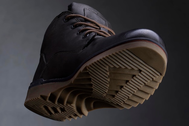 Leather boot on a dark background closeup view from below Autumn shoes