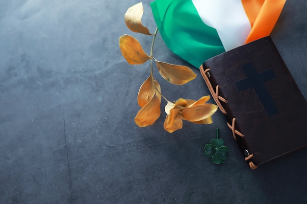 A leather-bound Bible on the table. Religious Christian Irish celebration. Four-leaf clover symbol of good luck.