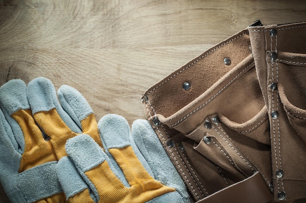 Leather building belt protective gloves on wooden board