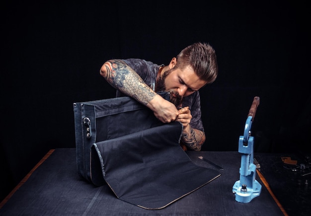 Photo leather handbag craftsman at work in a workshop