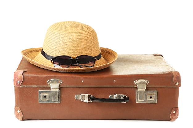 Leather old suitcase with hat isolated . Travel concept