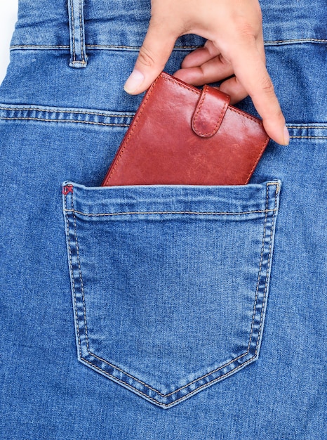  leather purse in the back pocket of blue jeans 