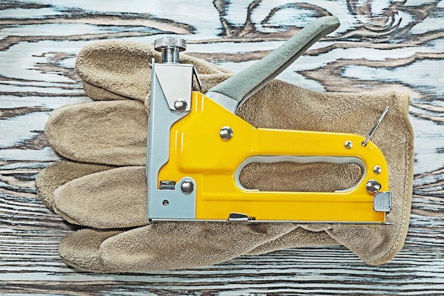 Leather safety gloves construction stapler on wooden board