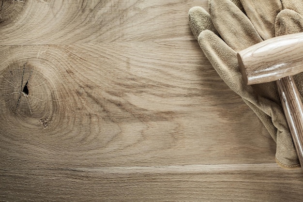 Leather safety gloves wooden mallet on wood board