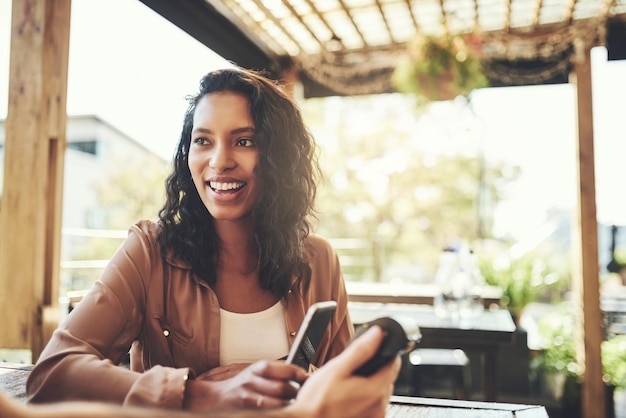 Leave your cash at home pay with your phone Shot of a young woman making a wireless payment in a coffee shop