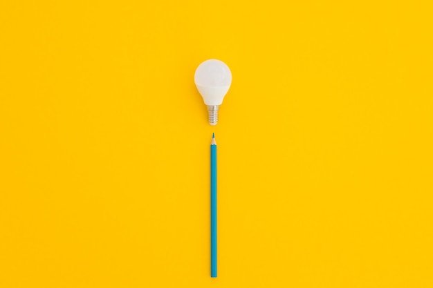 LED light bulb lies on a pastel yellow background Energy saving concept Minimalism top view