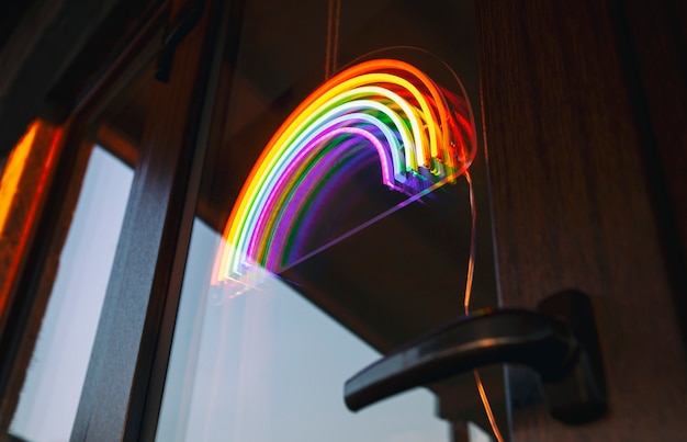 Photo the led neon rainbow hanging on the door entrance in the cafe