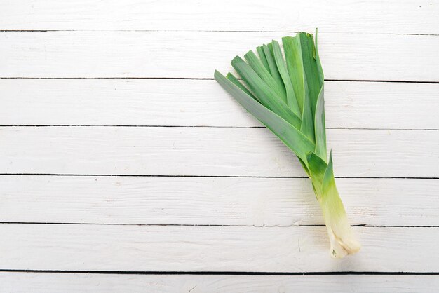 Leek on a white wooden background Top view Free space for your text