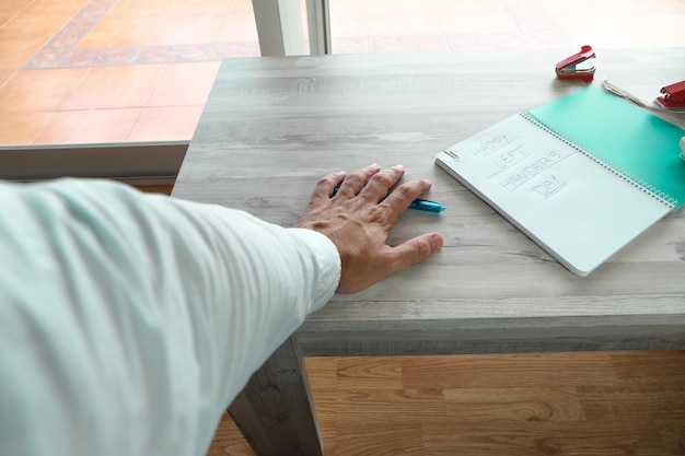 A left hand writing with a pen in a notebook for the international left-handed people's day.