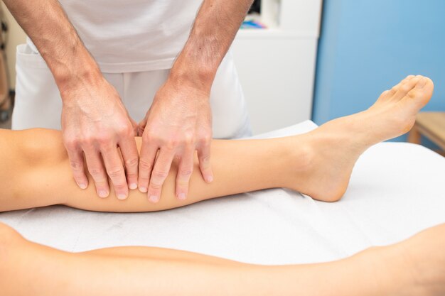 Leg treatment of an athlete by a physiotherapist