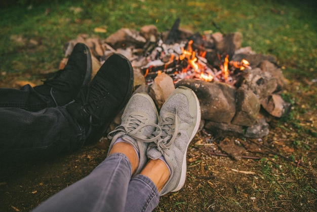 Leg of two persons in front of camp fire