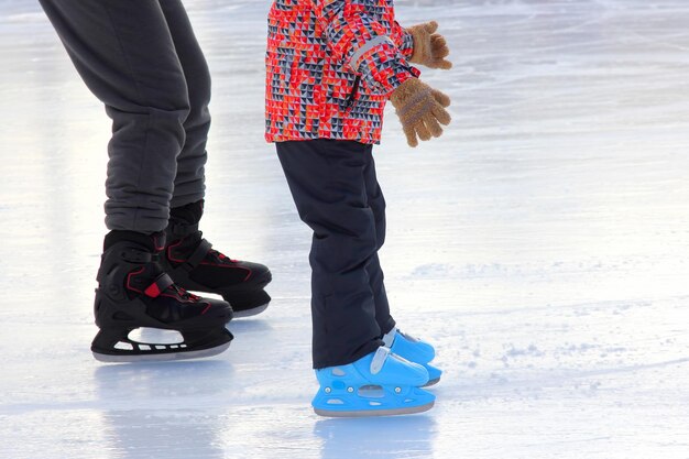 The legs of the child and adult ice skating rink