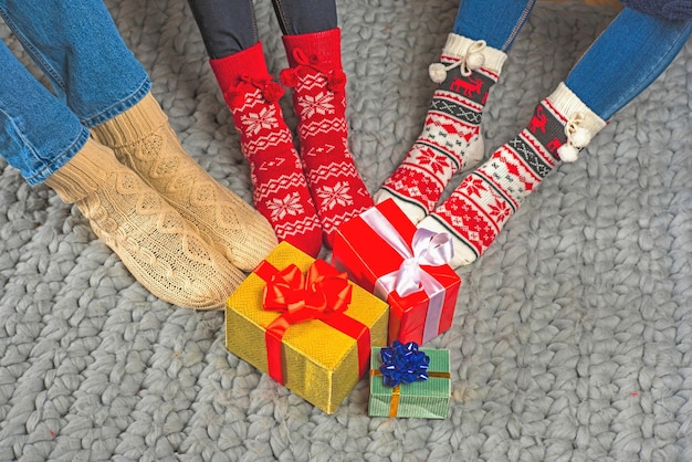 Photo legs in knitted socks and christmas presents