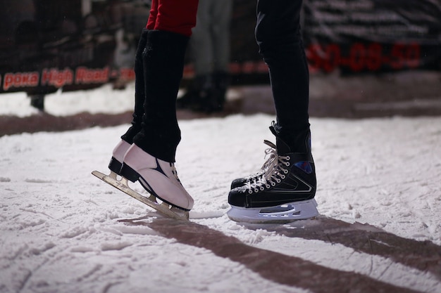 Legs of the loving kissing couple on skates. 