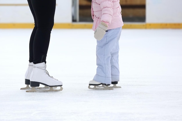 The legs of a man skating on an ice rink