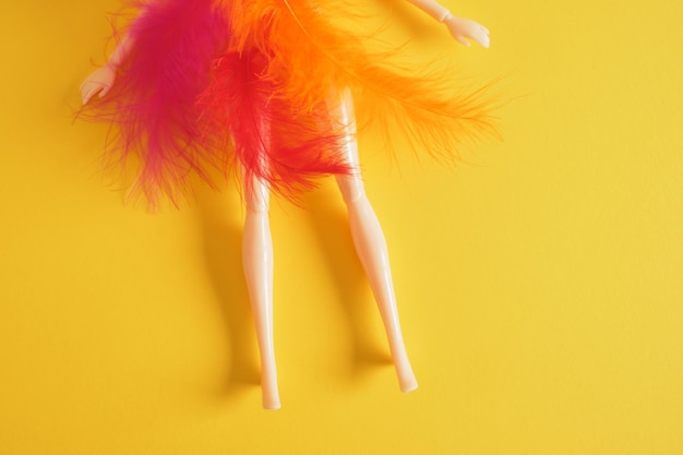 Legs of a plastic doll with feather feathers