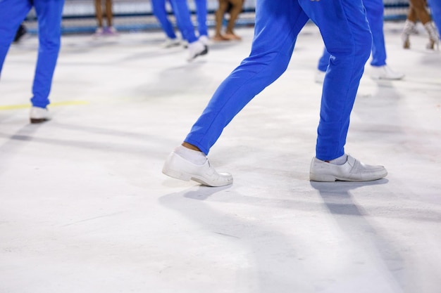 Legs of a sambista dancing with blue pants and white shoes at the sambodromo da marques de sapucai in Rio de Janeiro