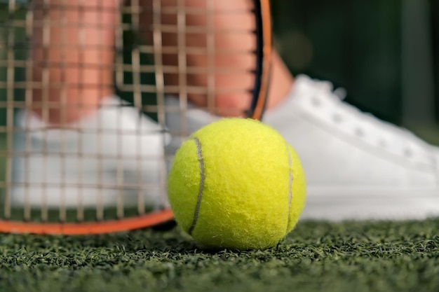 Legs and tennis racket closeup ball and racket on the tennis court