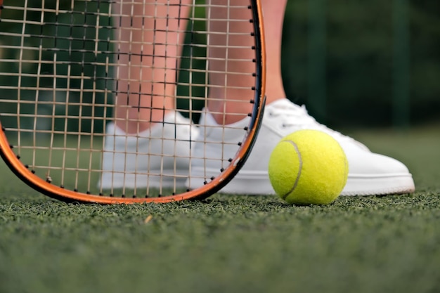 Legs and tennis racket closeup ball and racket on the tennis court