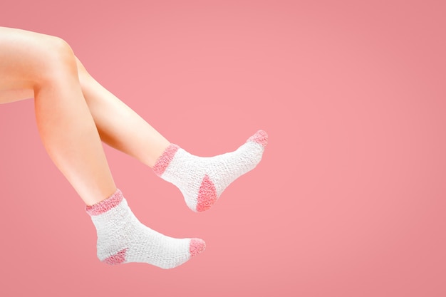 Legs of woman with fashion socks on pink background. 