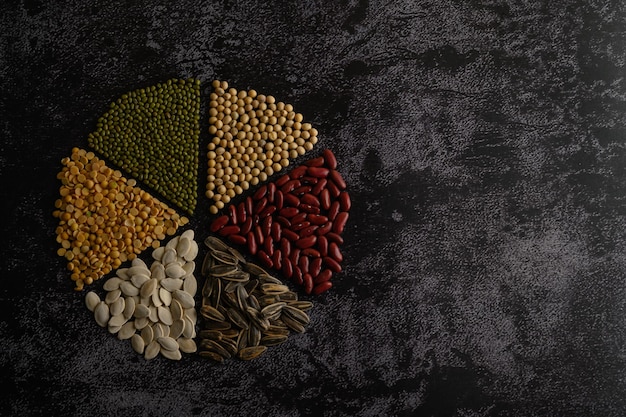 Legumes arranged in a circle on the black cement floor Top view