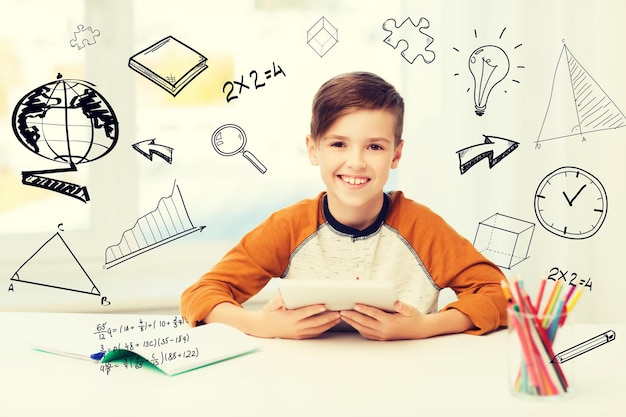 Photo leisure, children, education, technology and people concept - smiling boy with tablet pc computer and notebook at home over mathematical doodles