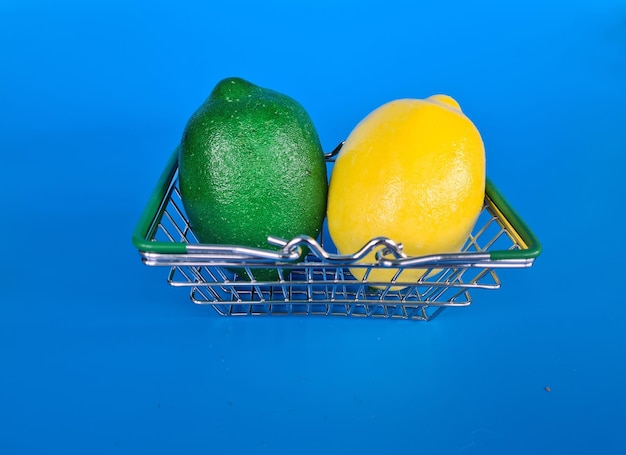 Lemon in a basket shopping trolley on a blue background