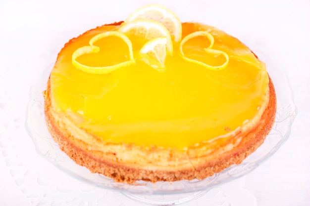 Lemon cheesecake on white background decorated with lemon zest close up