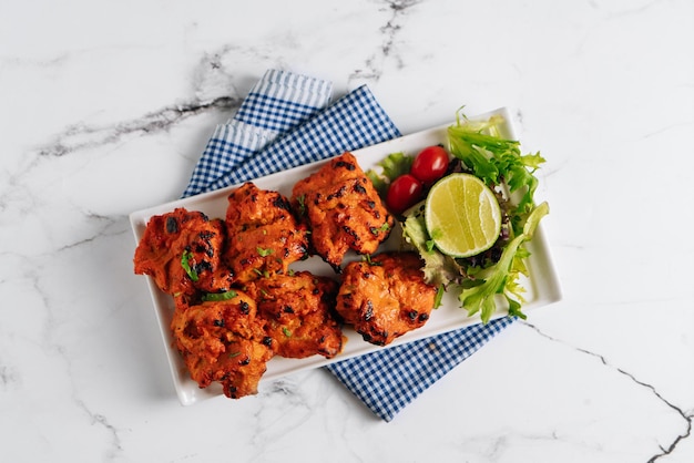 Lemon Chilli chicken Tikka Boti Kebab in a dish isolated on napkin side view on grey background famous indian and pakistani food