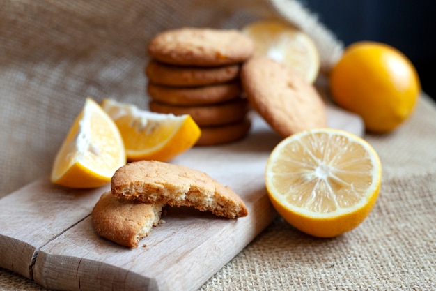 Lemon cookies and lemon slices on a wooden board