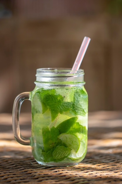 Lemon fruit Caipirinha alcoholic beverage of Brazil in glass mug on wooden table, close up