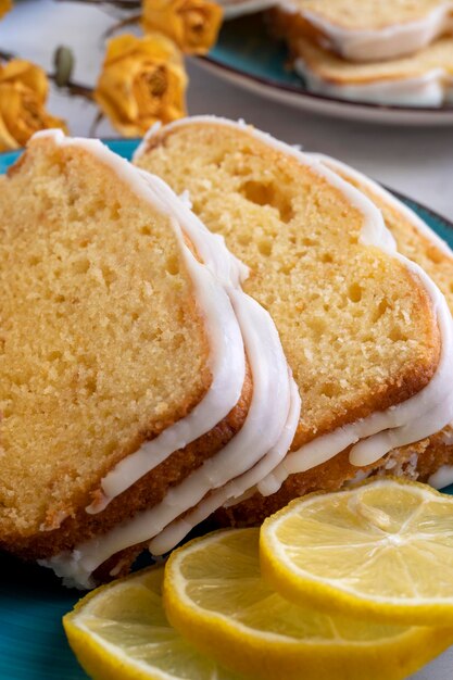 Lemon fruit cake on with lemon slices on blue plate, close up view. Delicious breakfast or tea time.