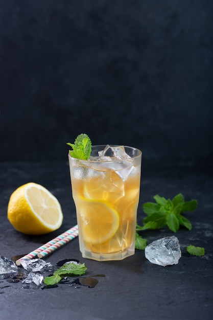 Lemon ice tea on dark background with mint and ice