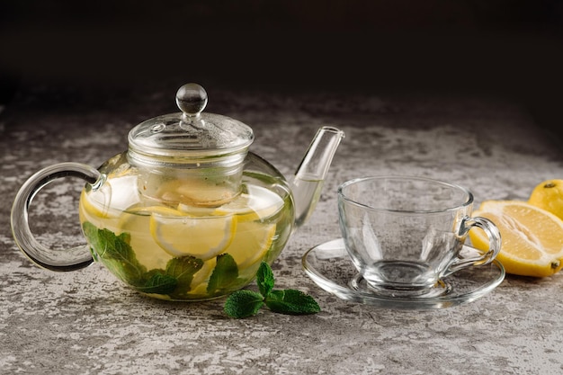 Lemon and mint tea in glass kettle