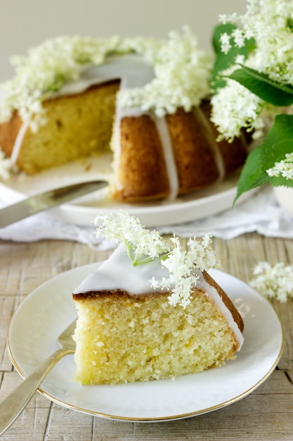 Lemon pie with a glaze of sugar and elderflower syrup, decorated with elderberry flowers. Rustic style.