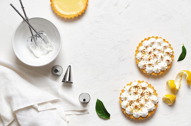 Lemon pies with meringue on a white background with copy space