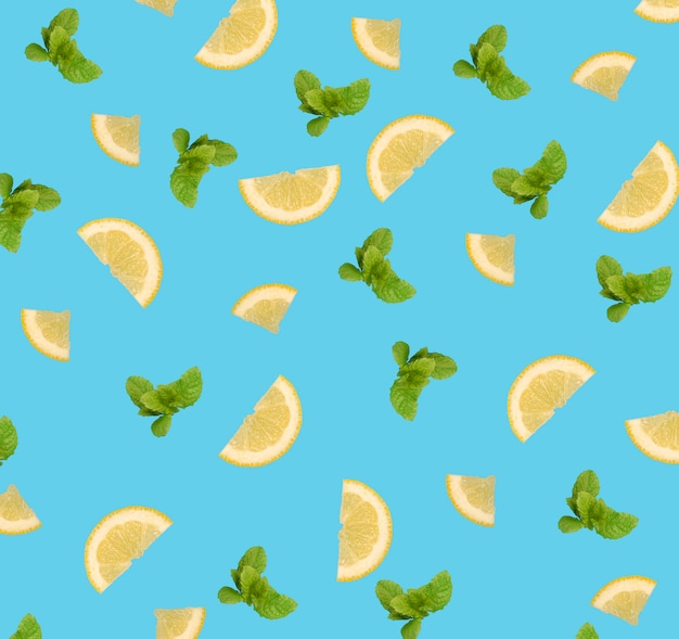 Lemon slices and mint leaves pattern on blue background